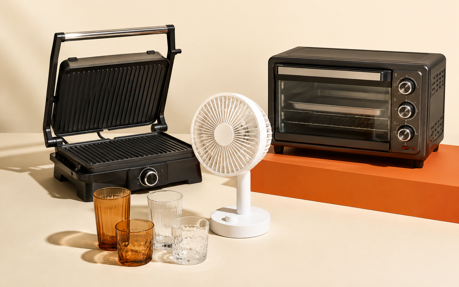 Auswahl aus Kontaktgrill, Ventilator, Gläsern und kleinem Backofen